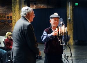 Henri Maizels and Dr. Roger Loria lighting a candle